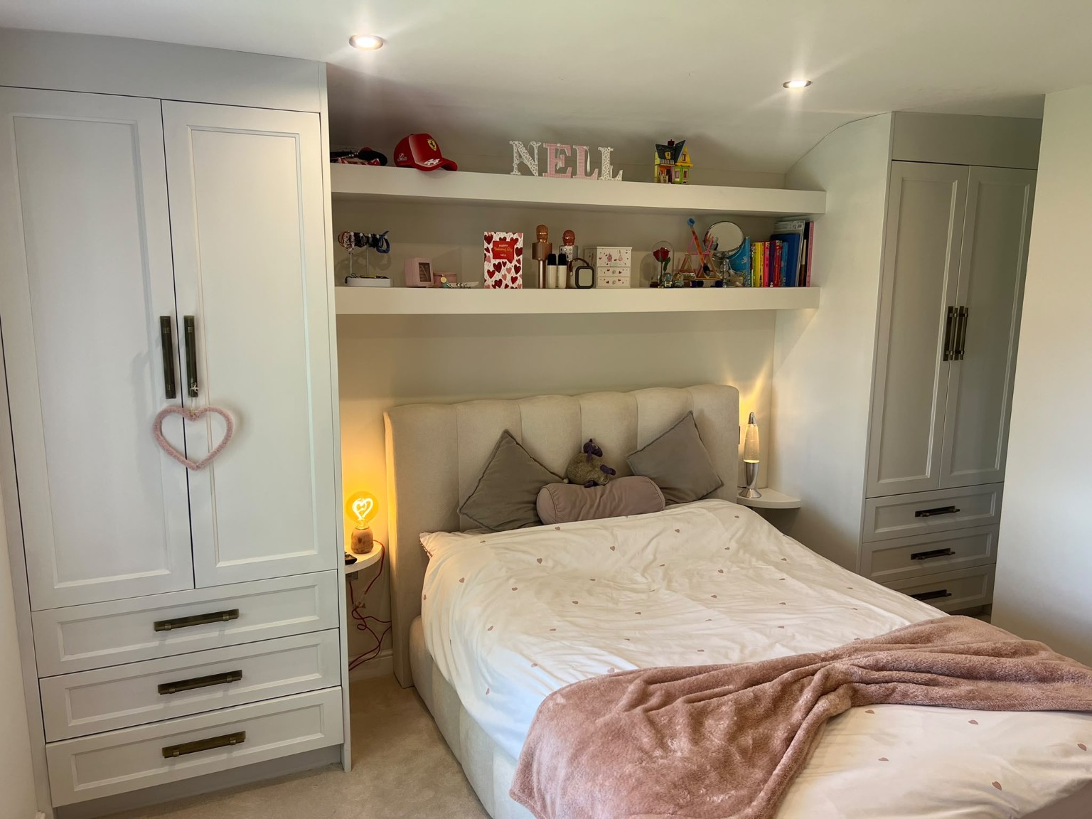 Spray-finished fitted wardrobes with drawers and shelving around a bed in Burley in Wharfedale