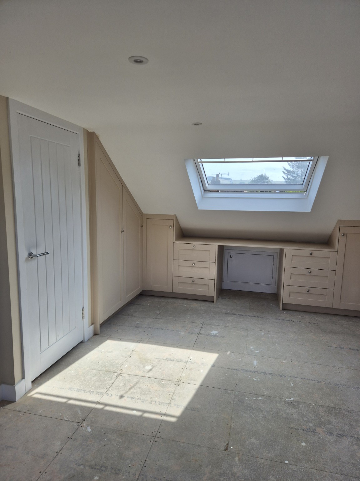 Bespoke fitted cabinetry beneath a sloping ceiling